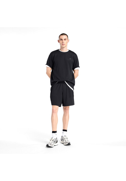Чоловік у чорній спортивній футболці New Balance Textured Check, шортах і кросівках у повний зріст спереду на білому тлі