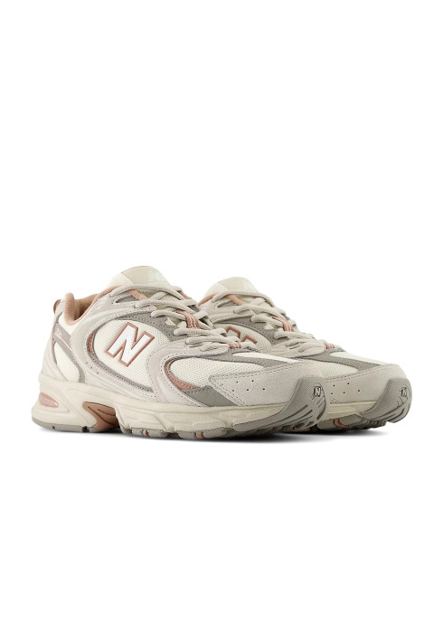 Унісекс кросівки New Balance 530 бежевого кольору під кутом спереду з логотипом N та сітчастим верхом