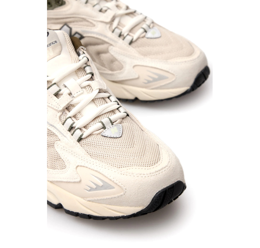 Деталь носка та шнурівки світлих кросівків New Balance 725 з сітчастим текстилем