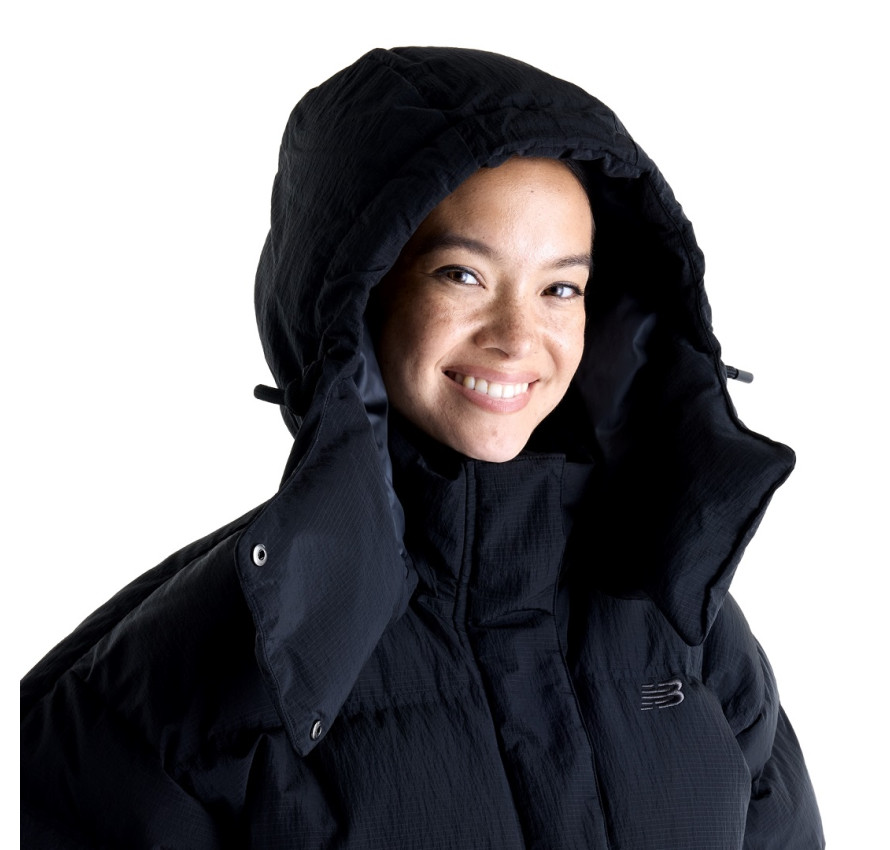 Портрет дівчини у надітому знімному капюшоні чорної куртки New Balance Premium Puffer