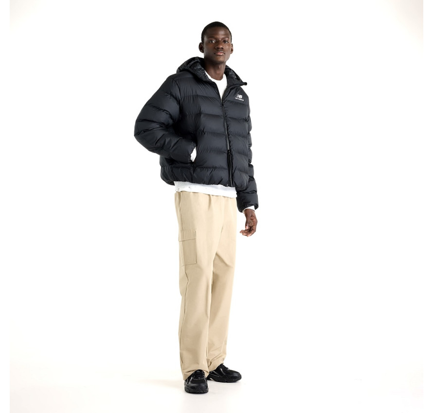 Чоловік у чорній куртці New Balance Boston Puffer та світлих штанах у повний зріст