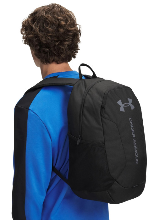Чоловік із чорним спортивним рюкзаком Under Armour Hustle Lite Backpack за спиною