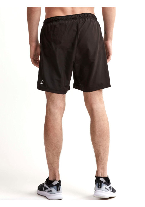 Чоловік у чорних тренувальних шортах Craft Eaze Woven Shorts вид ззаду на білому тлі