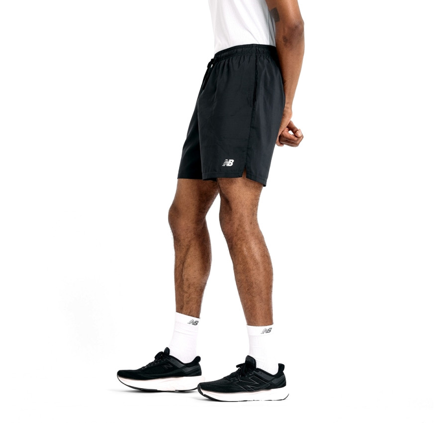 Чоловік у чорних спортивних шортах NB Sport Short 7" та білій футболці, вигляд спереду, фірмовий білий логотип на лівому стегні - фото 3