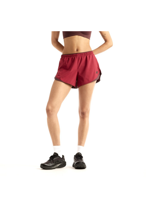 Дівчина у черврних бігових шортах New Balance RC Essentials Short 3'' та чорних кросівках, ракурс спереду