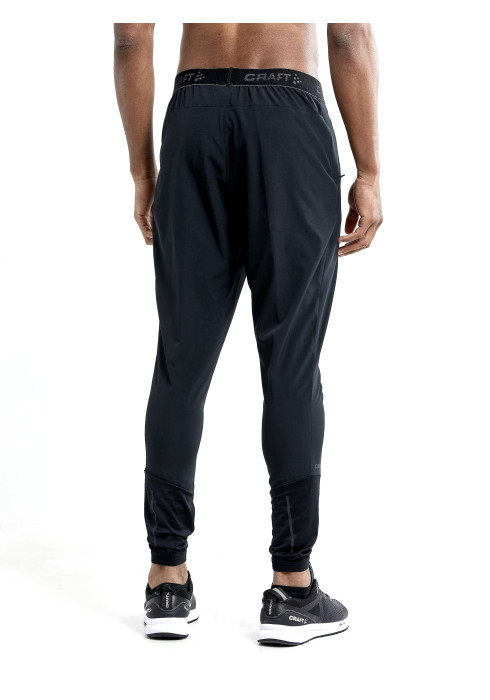 Чоловік у заужених чорних спортивних штанях Craft ADV Essence Training Pants вид ззаду на білому тлі