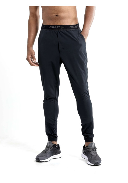 Чоловік у заужених чорних спортивних штанях Craft ADV Essence Training Pants студійний вигляд спереду на білому тлі