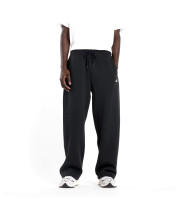 Чоловік у вільних чорних спортивних штанях New Balance Sport Essentials студійний вигляд спереду