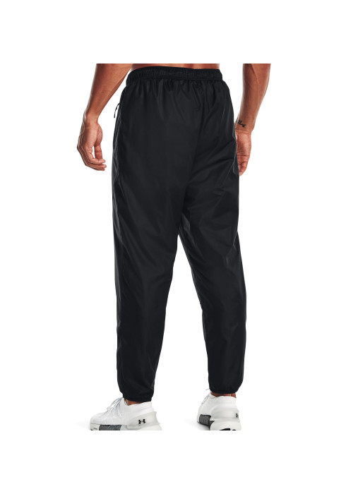 Чоловік у чорних спортивних штанах Under Armour UA RUSH Woven Pants та білих кросівках вид ззаду на білому тлі