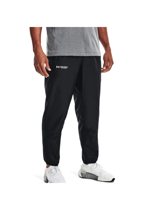 Чоловік у чорних спортивних штанах Under Armour UA RUSH™ Woven Pants студійний вигляд у три чверті на білому тлі