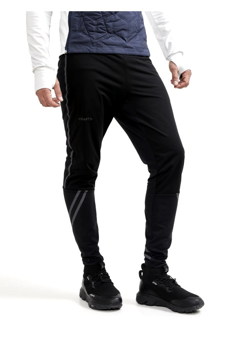 Чоловік у чорних вітронепроникних бігових штанах Craft ADV Lumen SubZ Wind Pants M студійний вигляд у три чверті