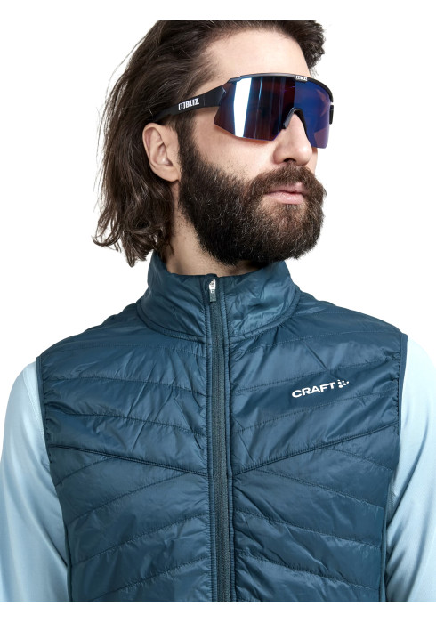 Чоловічий синьо-зелений жилет Craft ADV Essence Warm Vest крупним планом спереду на моделі в окулярах